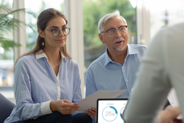 Charming brunette longhaired female person holding documents