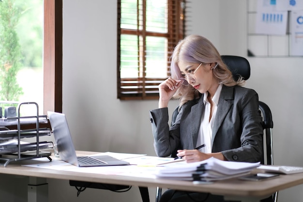 Charming businesswoman working on laptop at her workplace at modern office