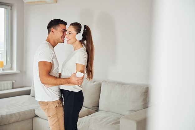 Charming couple listening to music together at home