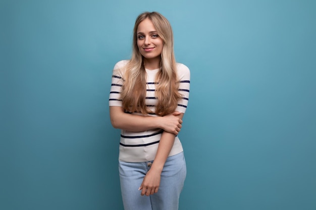 Charming girl in casual clothes posing on a blue isolated background