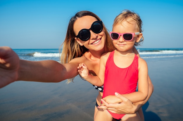 Charming little girl and her mom are photographed on the phone