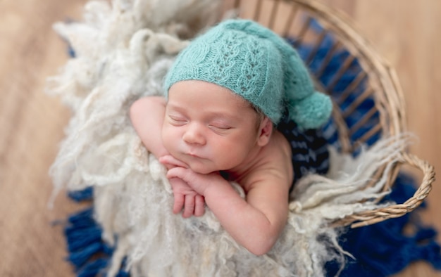 Charming newborn baby boy sleeping in basket