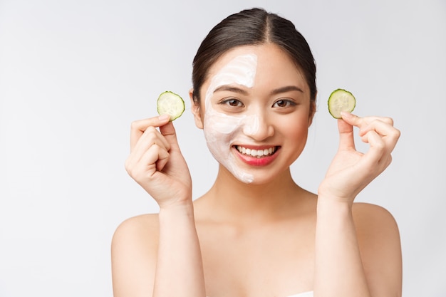 Charming pleasant woman applying cream on half face