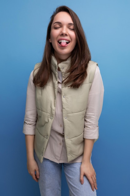 Charming positive brunette young lady in casual style on studio background