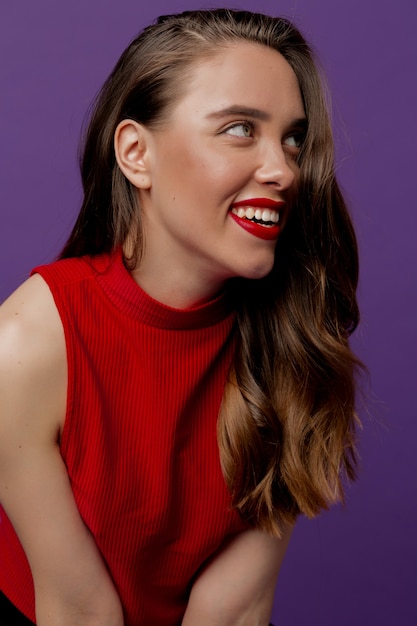 Charming romantic girl with red lipstick looking up and posing in studio