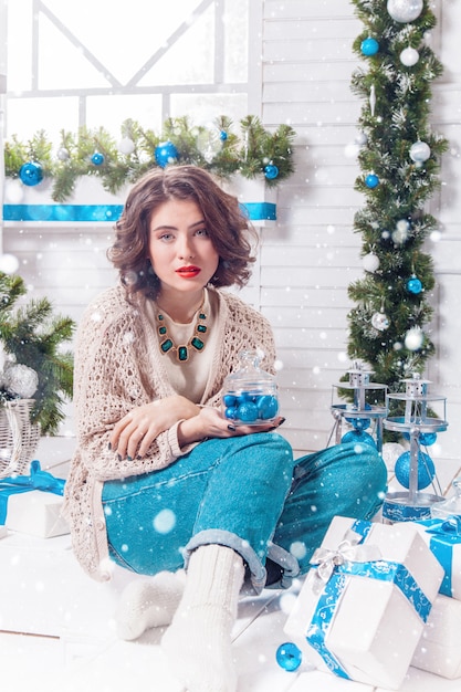 Charming sexy girl with red lipstick in a knitted sweater 