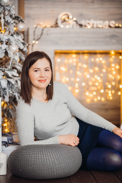 Charming woman lies on the floor before a fireplace