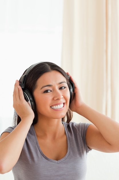 Charming woman with earphones looking into camera