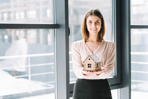 Charming woman with toy house