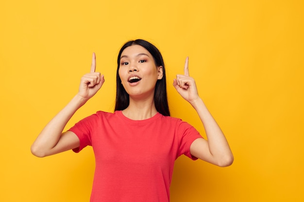 Charming young Asian woman gestures with her hands in casual clothes copyspace studio model unaltered