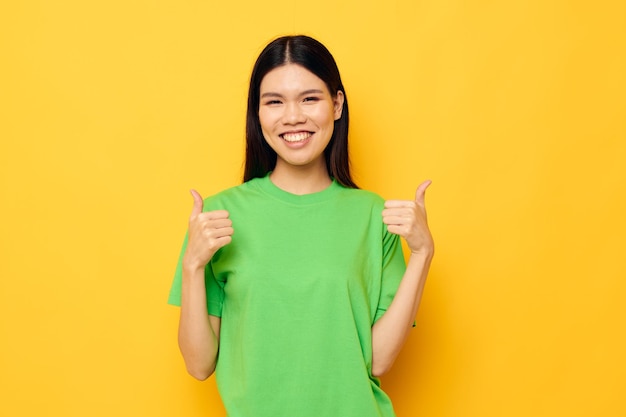 Charming young Asian woman in green tshirts gestures with his hands emotions studio model unaltered