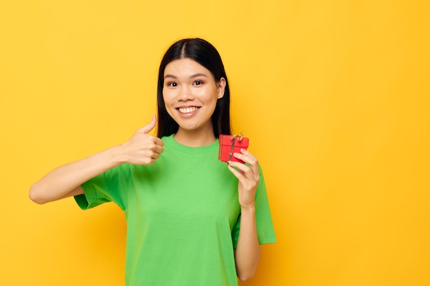 Charming young Asian woman with a small gift box holiday isolated background unaltered