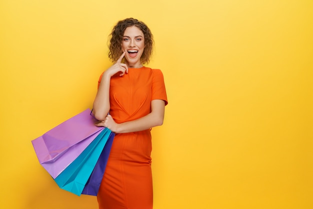 Charming young customer standing with colorful paper bags