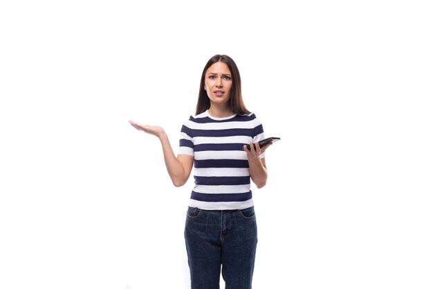 Charming young european woman with black straight hair in a striped black and white tshirt and jeans