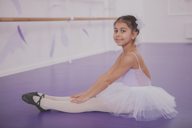 Charming young girl ballerina exercising at dance school