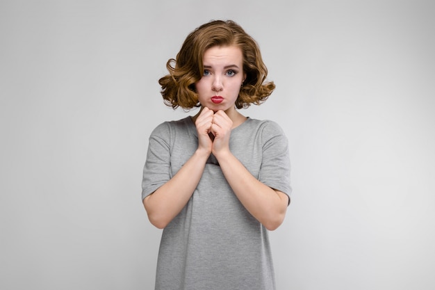 Charming young girl in a gray T-shirt on gray 