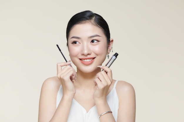 Charming young woman applying mascara