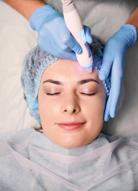 Charming young woman having skincare procedure in beauty salon