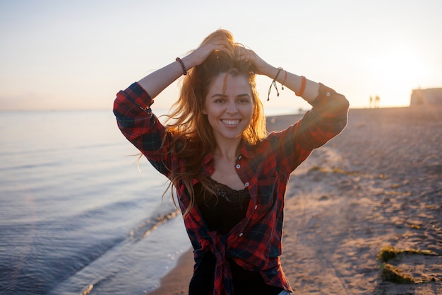 Charming young woman walks on the beach.