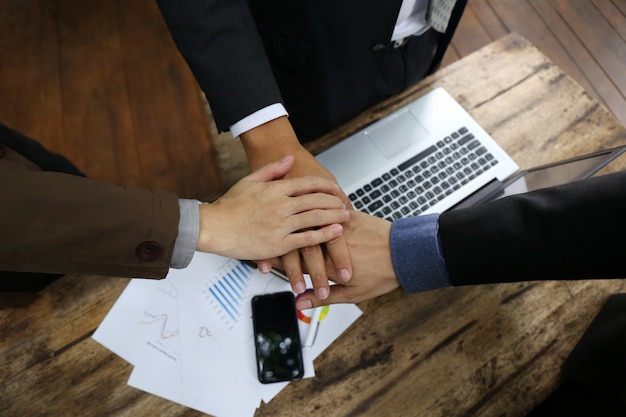 Chart document on table and Teamwork Join Hands