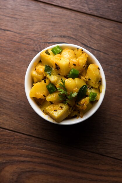 Photo chatpate masala aloo sabzi fry or bombay potatoes served in a bowl, selective focus