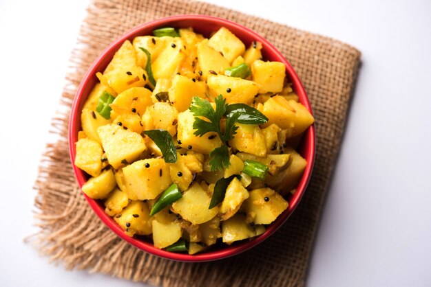 Photo chatpate masala aloo sabzi fry or bombay potatoes served in a bowl, selective focus