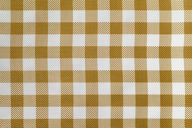 Checkered tablecloth for the table beige and white cells pattern Background texture of brown textile napkin