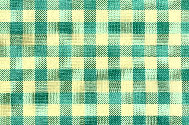 Checkered tablecloth for the table light yellow and green cells pattern Background texture of olive textile napkin