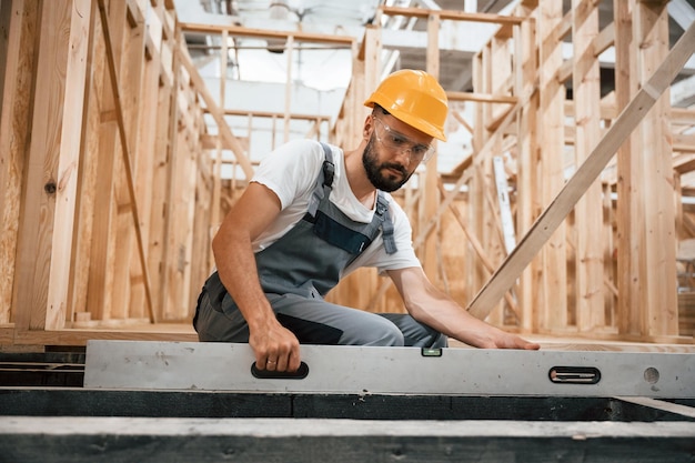 Checking the straight by using leveling tool Industrial worker in wooden warehouse