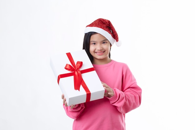 Cheered and happy Christmas Asian girl wearing a Santa hat holding gift box