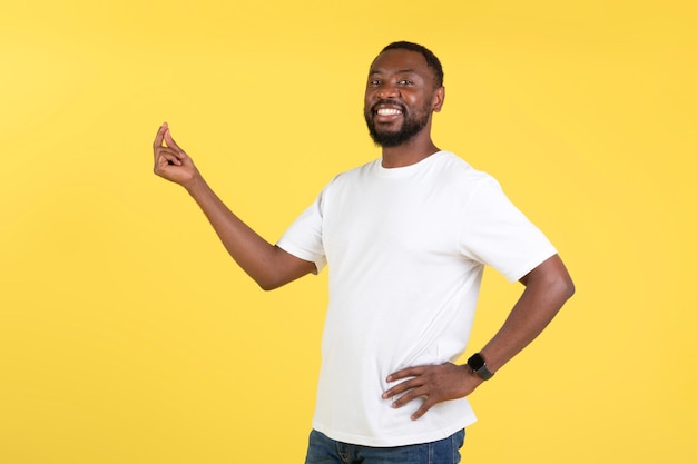 Cheerful African American Guy Clicking Fingers Standing Over Yellow Background