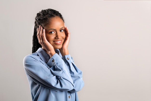 Cheerful African woman touching face