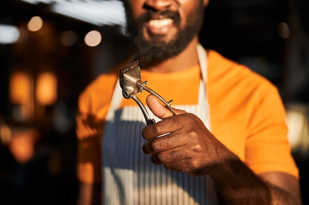 Cheerful Afro American man holding hair trimmer