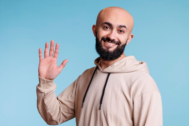 Cheerful arab man waving hi portrait