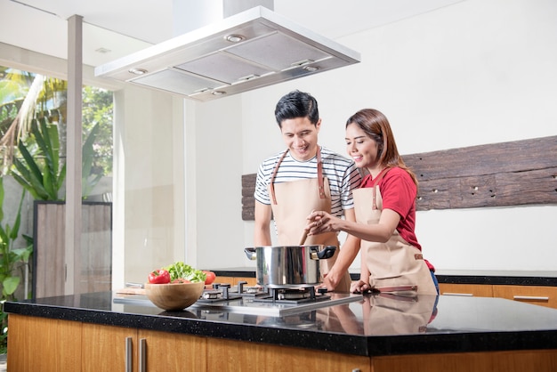 Cheerful asian couple cooking together