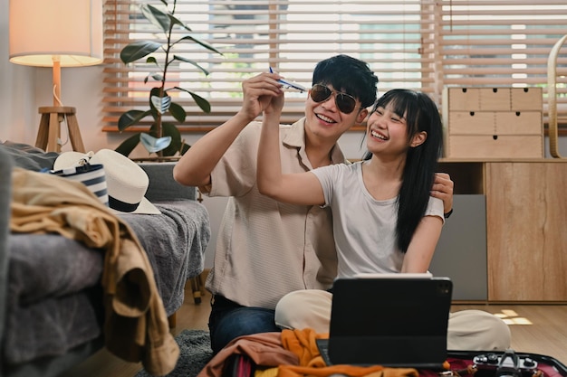 Cheerful Asian couple holding airplane model ready for vacation Traveling vacation and transportation concept