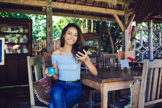 Cheerful Asian woman using phone smiling