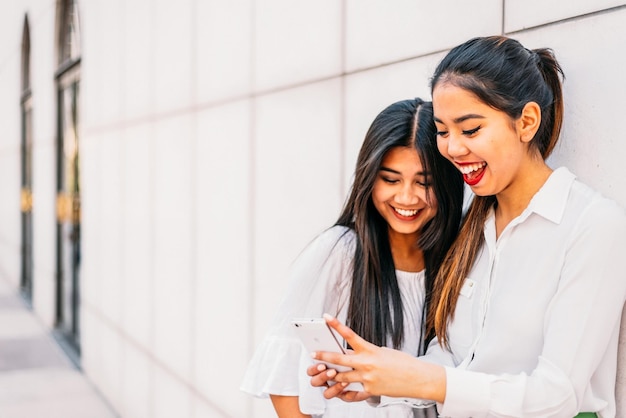 Cheerful Asian woman using smartphone