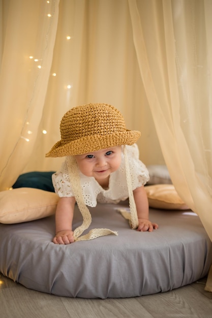 Cheerful baby girl crawls on a mattress over a canopy