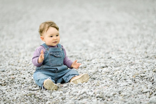 Cheerful baby girl playing on the beach