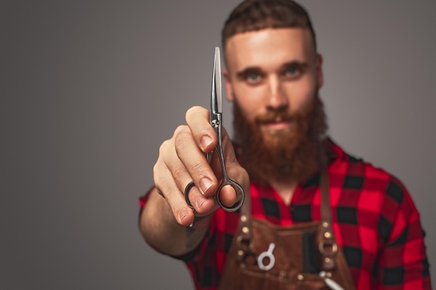 Cheerful barber showing scissors