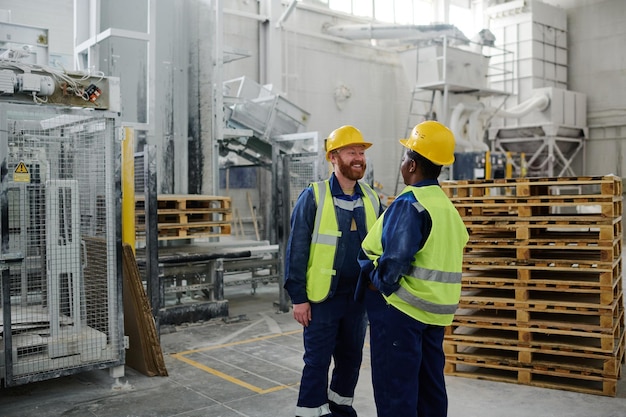 Cheerful bearded male engineer standing in front of female colleague