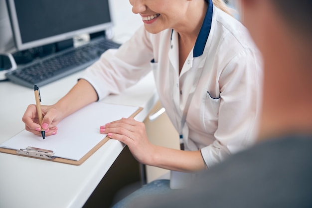 Cheerful beautiful doctor during appointment with man