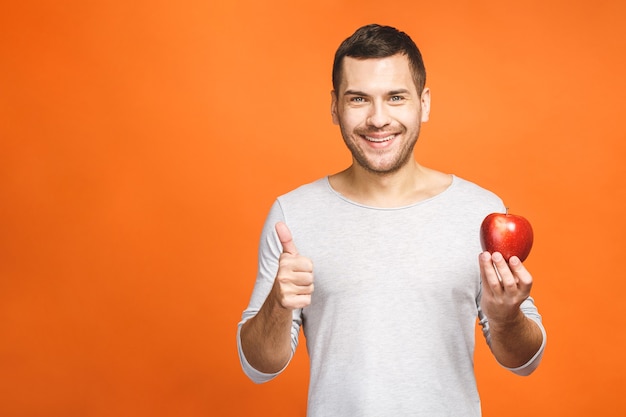 Cheerful beautiful man eating apple