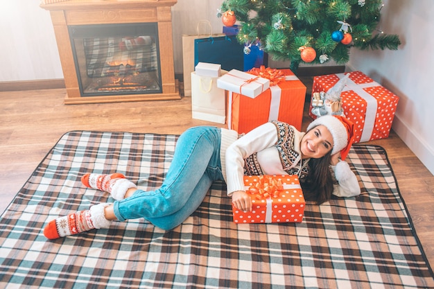 Cheerful and beutiful model lying on floor and posing. She looks on camera and smiles.