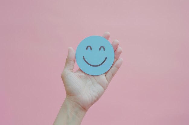 Photo cheerful blue smiley face on pink background a minimalist design symbolizing happiness