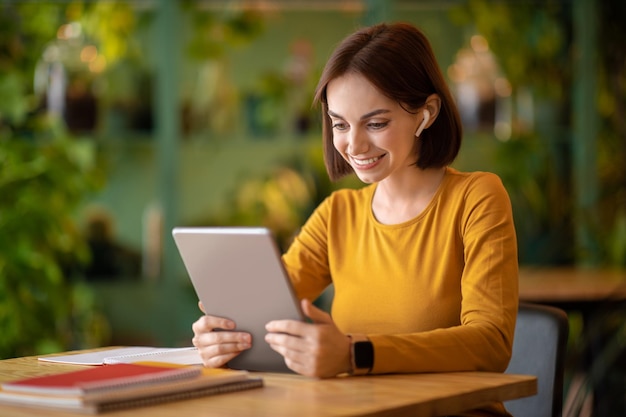 Cheerful brunette lady freelancer working at cafe