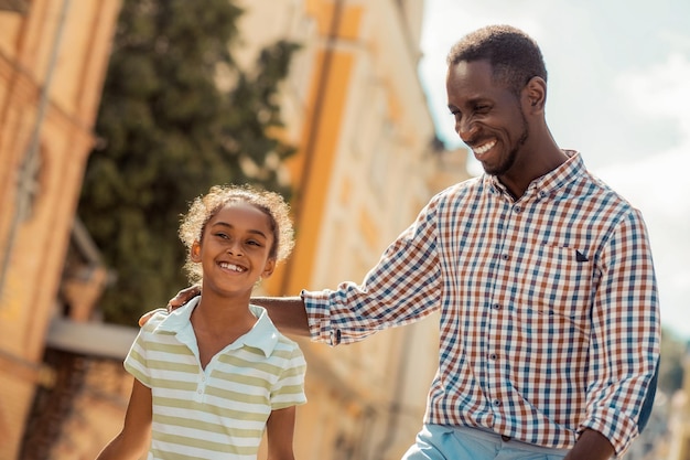 Cheerful brunette male person embracing his kid