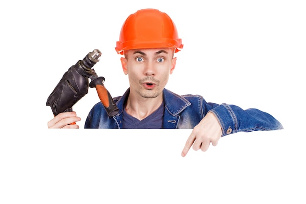 A cheerful builder holds a drill in his hand on an isolated white background