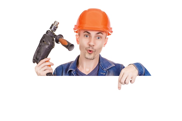 A cheerful builderholds a drill in his hand on an isolated white background Emotional photo